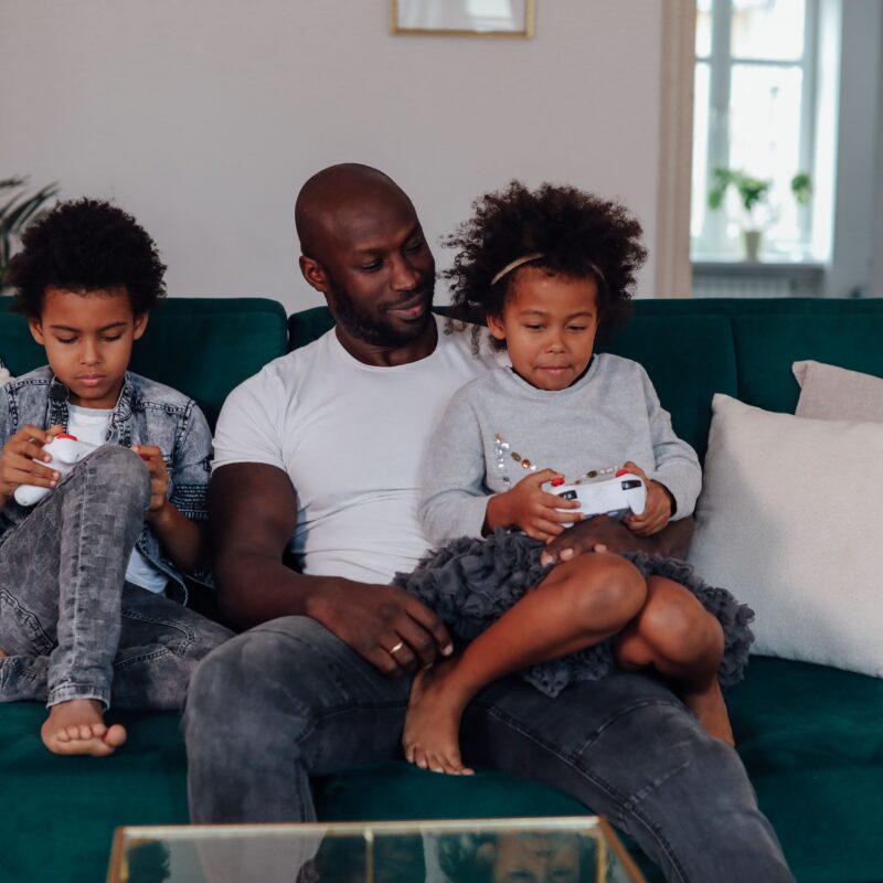 Parent sitting with child on a sofa at home, sharing a quiet moment together.